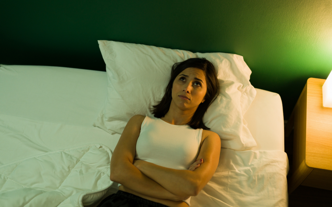 woman lying on her bed at night, unable to sleep